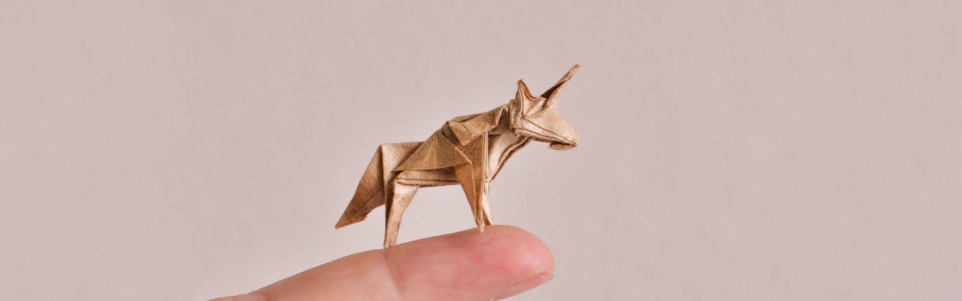 Paper unicorn on extended finger