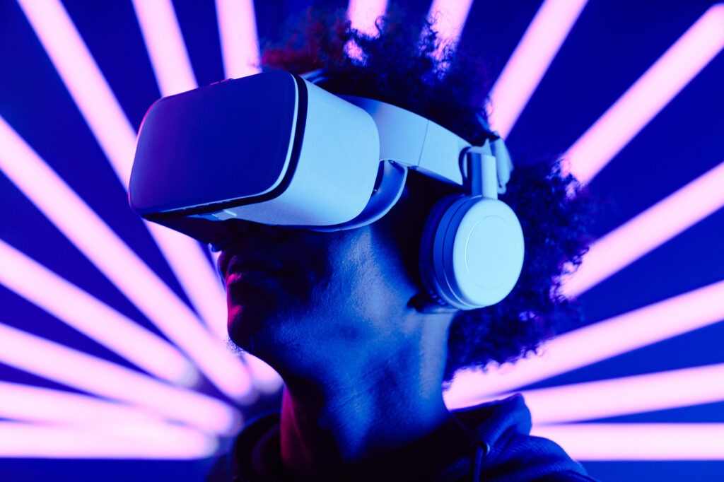 Person wearing a VR headset with flashing purple lights behind them